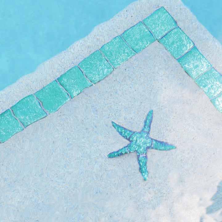 Close-up of a starfish on a sandy surface with turquoise tiles in the background