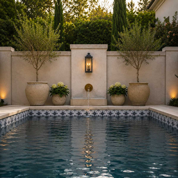 Pool area with decorative wall, potted plants, and a light fixture.