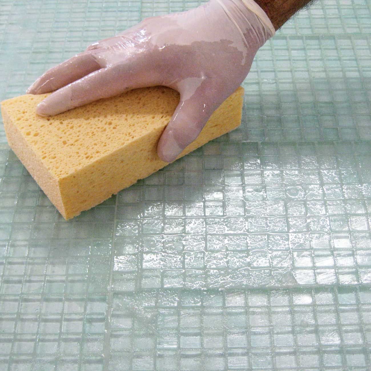 Person Cleaning Off Grout Residue
