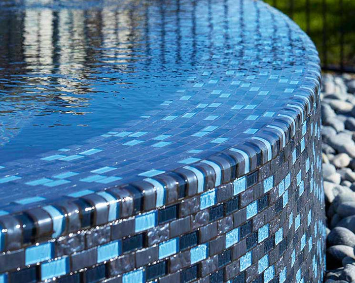 Metallic Blue Blend 1x2 Glass Tile Installed on Infinity Pool Around Wall