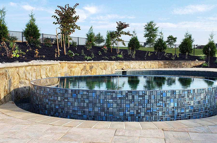 Steel Gray Mixed Glass Pool Tile Around A Raised Spa